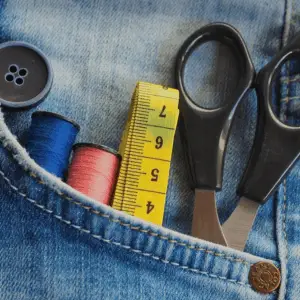 Hosentasche mit Knopf, Schere, Faden und Messband